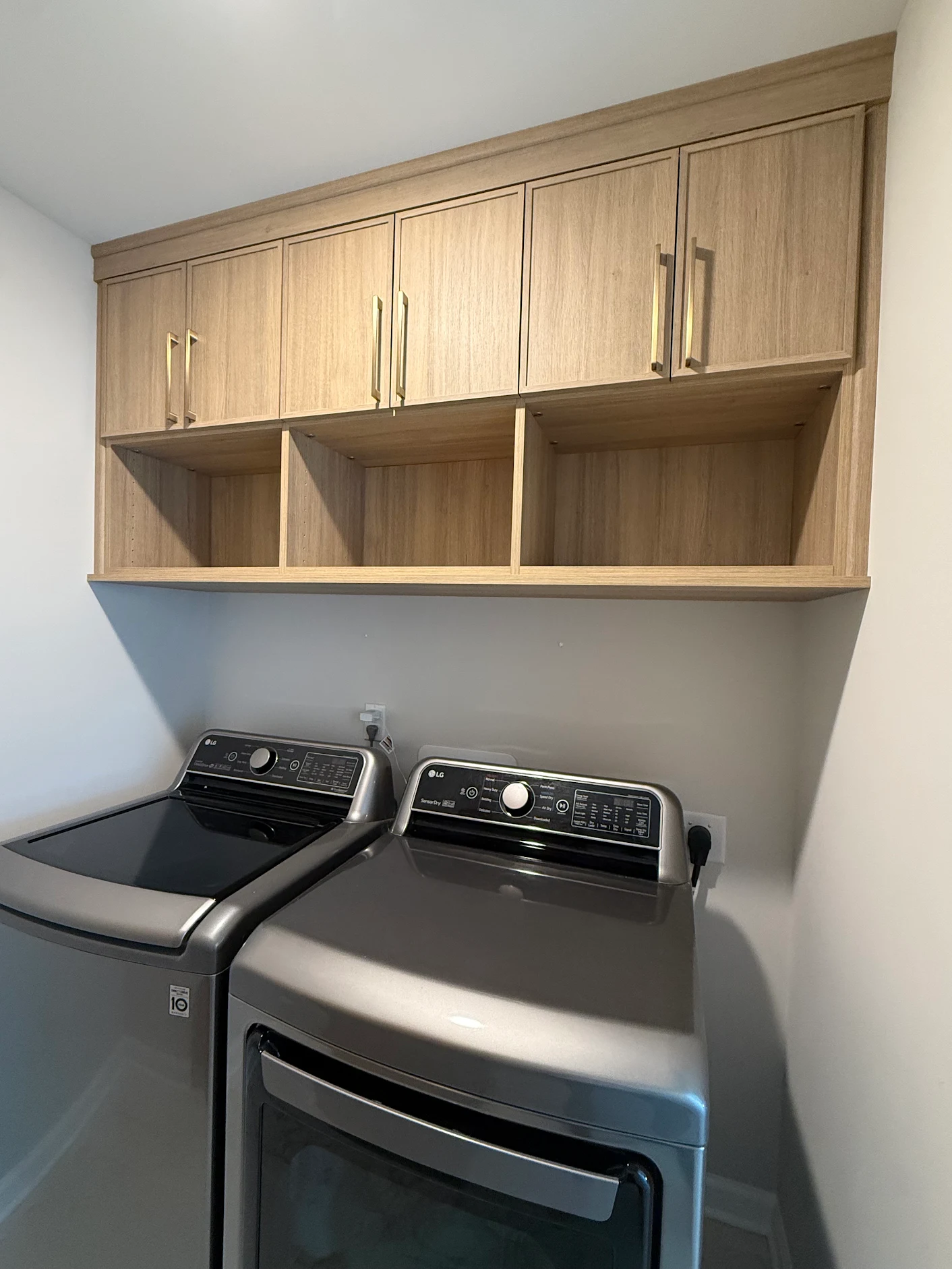 Custom laundry room cabinetry above washer and dryer